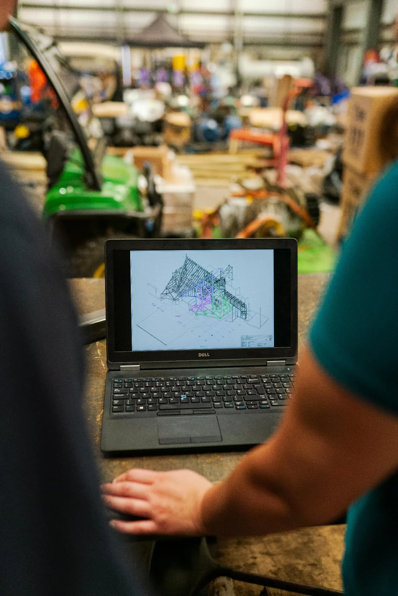Engineers reviewing a structural design on a laptop in a workshop