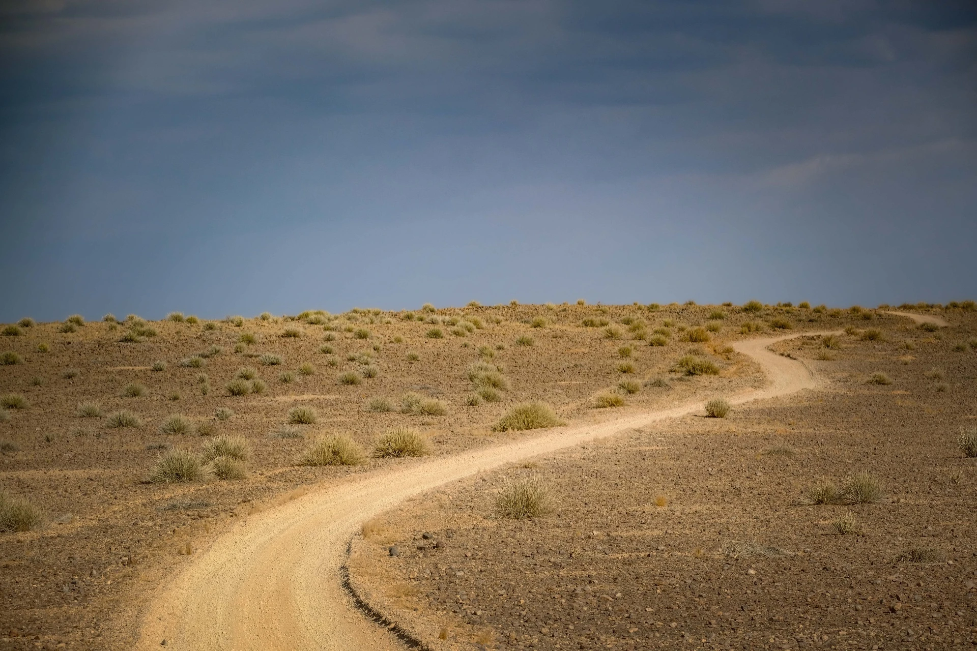 A clear walking track crossing open mountain terrain